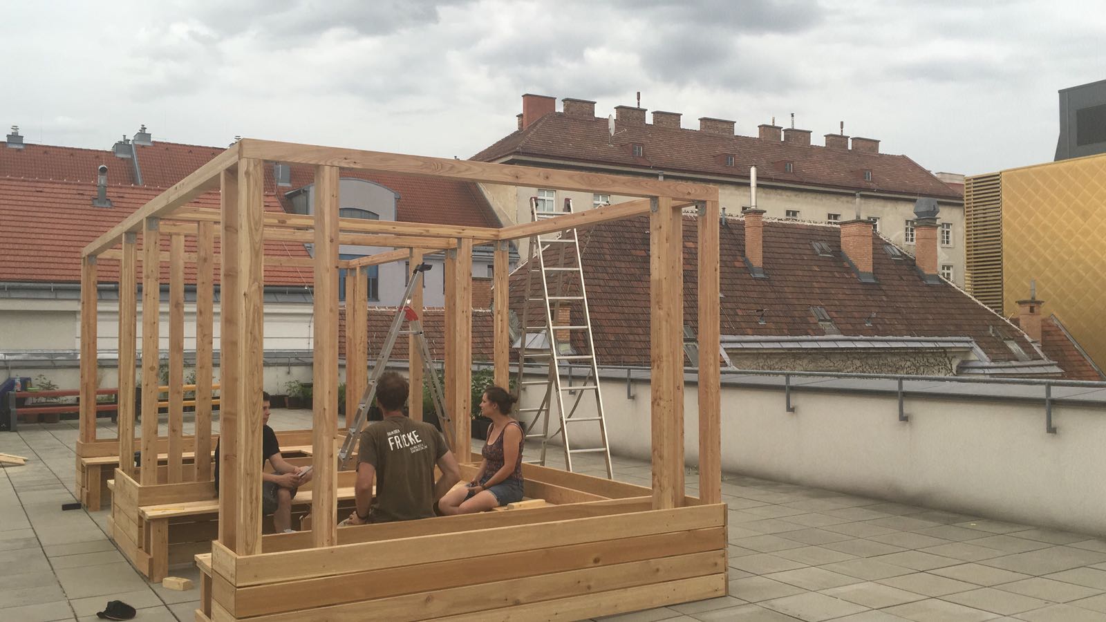 Die Holzkonstruktion mit zwei Modulen steht und die Sitzbänke werden von erschöpften Konstrukteurinnen und Konstrukteuren auf die Standfestigkeit überprüft ?